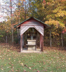 picture of a well in a forest backdrop